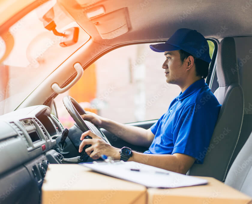 配送車で運転する配達員